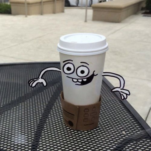 Ein Kaffeebecher ist lebendig und hat ein lachendes Gesicht.